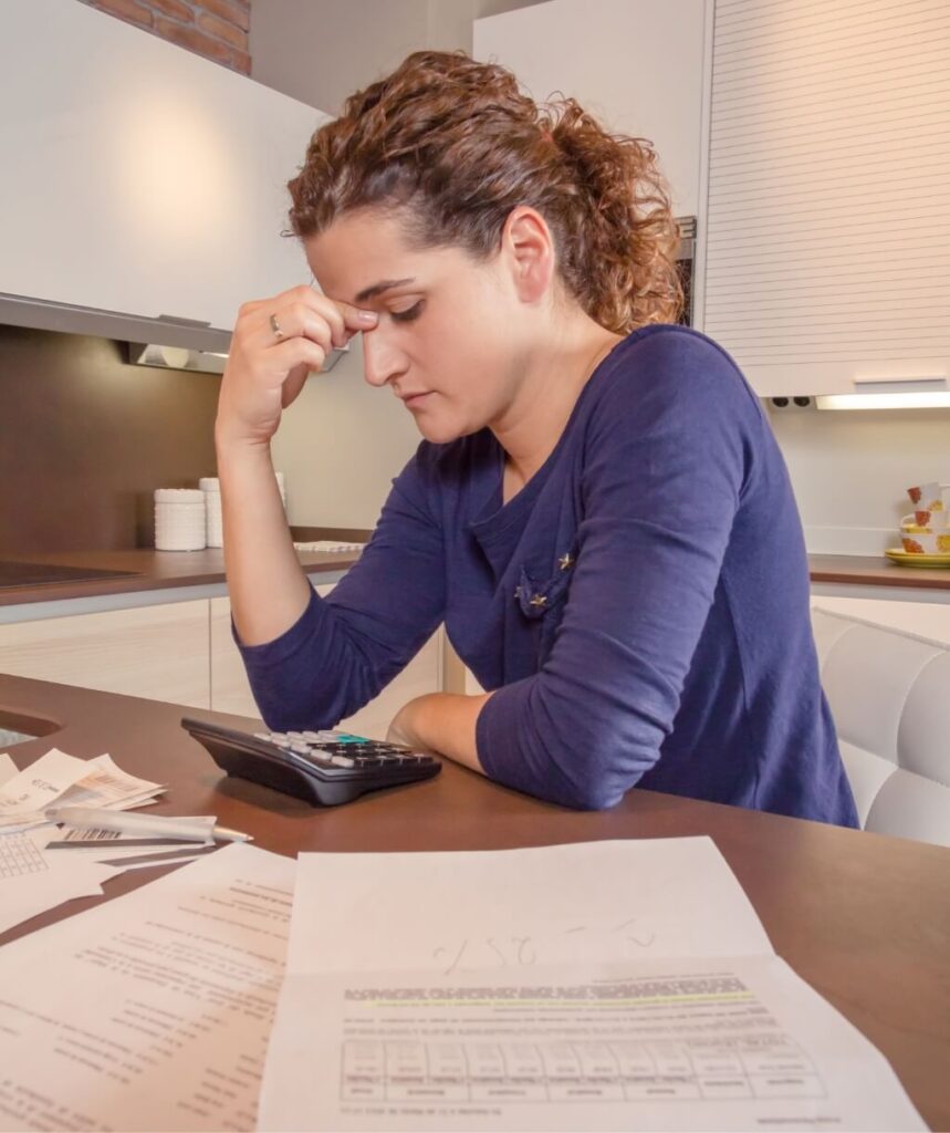 unemployed-woman-with-debts-review-monthly-bills-B2SU7AH.jpg